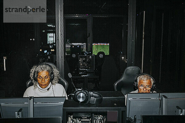 Ältere männliche und weibliche Freunde spielen Videospiele auf Computern in der Gaming-Lounge