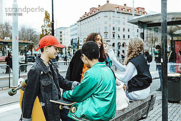 Gemischtrassige Freundinnen und Freunde verbringen gemeinsam ihre Freizeit in der Stadt