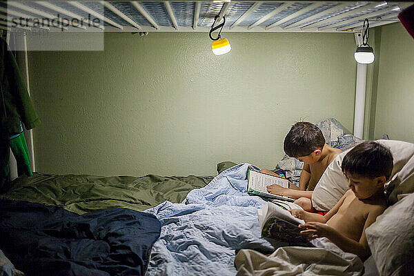 Zwei japanisch-amerikanische Brüder lesen Bücher im Bett