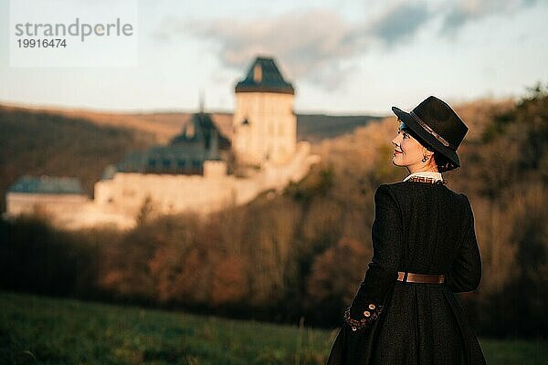 Junge Frau im historischen Retro-Kostüm im Morgengrauen in der Nähe des Schlosses