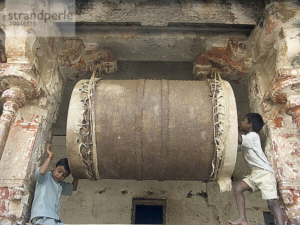 Kinder schlagen auf einer riesigen Trommel im Hindu-Tempel in Hampi  Karnataka  Indien.