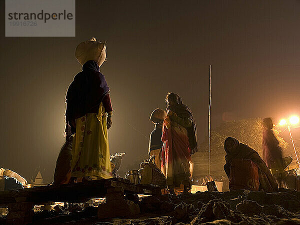Pilger vor Sonnenaufgang in der Nähe des heiligen Flusses Ganges in Varanasi  Uttar Pradesh  Indien