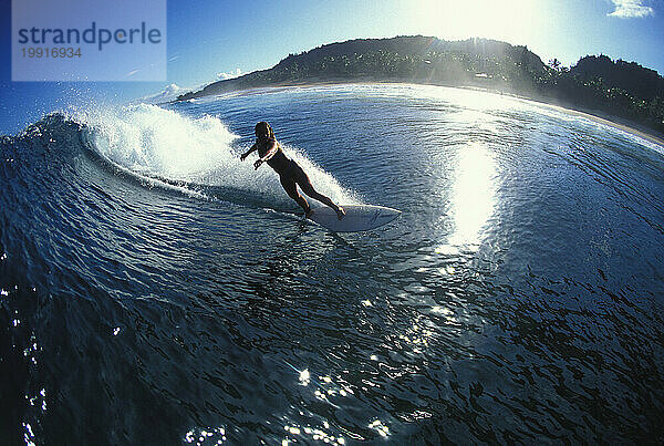 Frau surft an der Nordküste von Hawaii