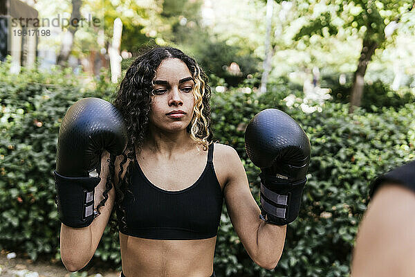 Konzentrierte Frau übt Kampf mit Boxhandschuhen