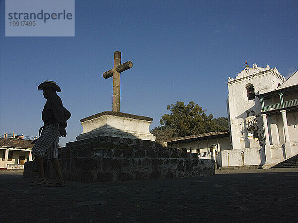 Ein Mann geht in seiner Silhouette vor einer Kirche. Santiago  Guatemala.