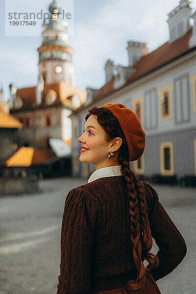 Junge Frau in Retro-Kleidung in der Sonne in einer alten europäischen Stadt