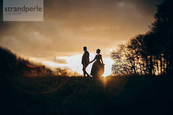 Verliebtes Paar in historischen Kostümen im Herbstwald bei Sonnenaufgang