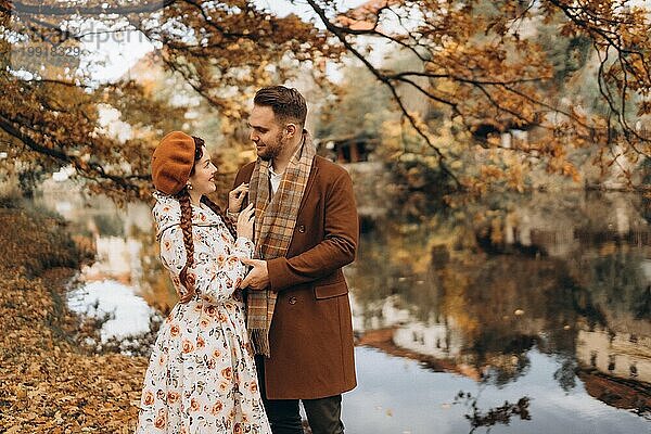 Ein Mann und eine Frau in Mänteln gehen bei einem Date durch einen Herbstpark