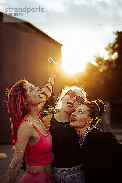 Drei glückliche Freundinnen bei Sonnenuntergang  emotionales Porträt  Freundschaft.