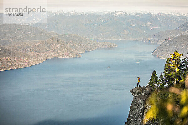 Mann steht am Rand einer Klippe mit Blick auf Howe Sound  Vancouver