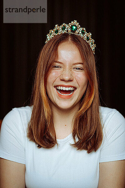 Fröhliches emotionales Porträt eines lachenden Teenager-Mädchens mit roten Haaren.