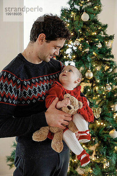 Zärtlicher Weihnachtsmoment zwischen Papa und Baby