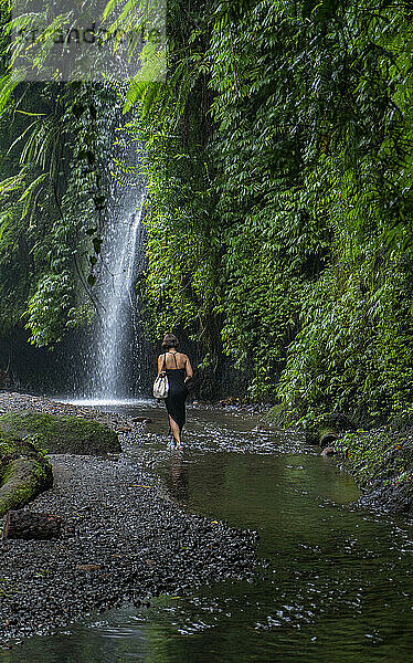 Frau erkundet den Wasserfall Tukad Cepung auf Bali