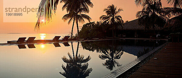 Panoramablick auf den Pool und die Silhouette der Palmen