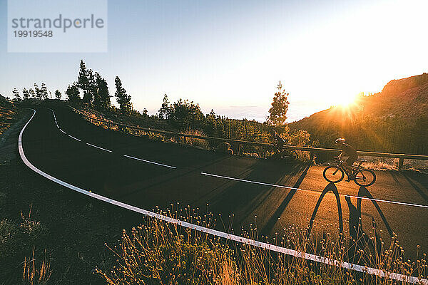 Zwei Radfahrer fahren bei Sonnenuntergang hinauf  Kanarische Inseln  Spanien