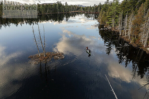 Zwei Personen paddeln mit dem Kanu um die Insel am Trout Pond  Maine