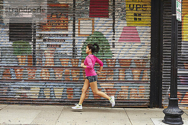 Eine junge asiatische Frau läuft durch die Straßen des North End von Boston  MA.