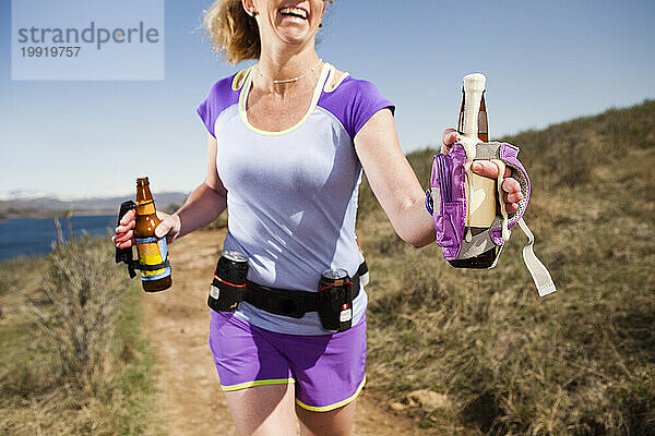 Fröhliche sportliche Frauen beim Trailrunning mit Session-Bieren