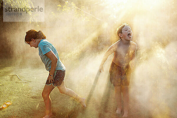 Zwei Kinder spielen im Wasser im Hinterhof