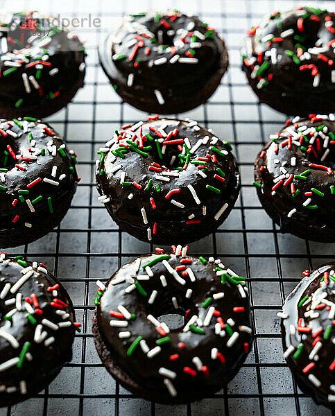 Nahaufnahme von Donuts mit Schokoladenglasur und Weihnachtsstreuseln.