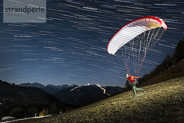 Mann startet beim Speedfliegen in den Alpen bei Nacht  Bruneck  Südtirol  Italien