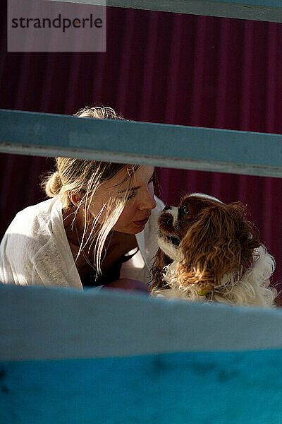 Liebevolle Frau  die Hund küsst. Kavalier Charles.