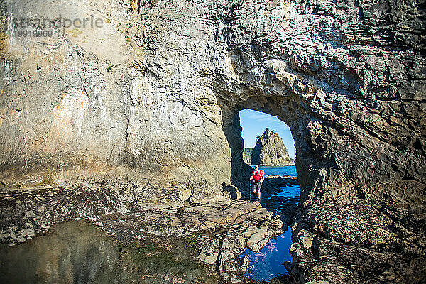 Wanderer geht durch den Hole-In-The-Wall  Olympic National Park