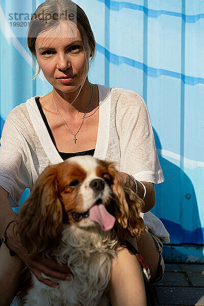 Junge Frau geht mit einem Hund  Cavalier Charles  spazieren.