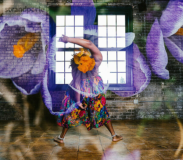 Double exposure of purple flowers over black female dancer pose