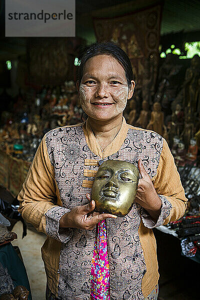 Porträt einer Kunsthandwerksverkäuferin  die Masken im Tempelkomplex in der Nähe des Inle-Sees  Shan-Staat  Myanmar  verkauft