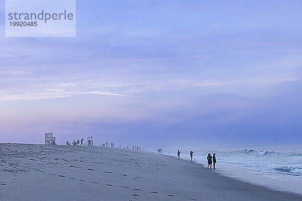 Silhouetten von Menschen am Nauset Beach auf Cape Cod bei Sonnenuntergang