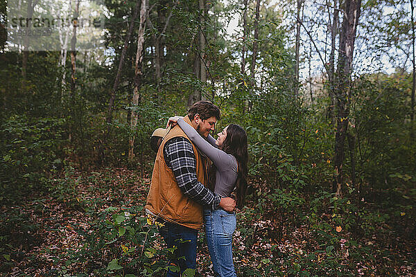 Junges Paar umarmt sich im Wald
