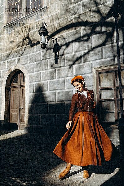 Junge Frau in Retro-Kleidung in der Sonne in einer alten europäischen Stadt