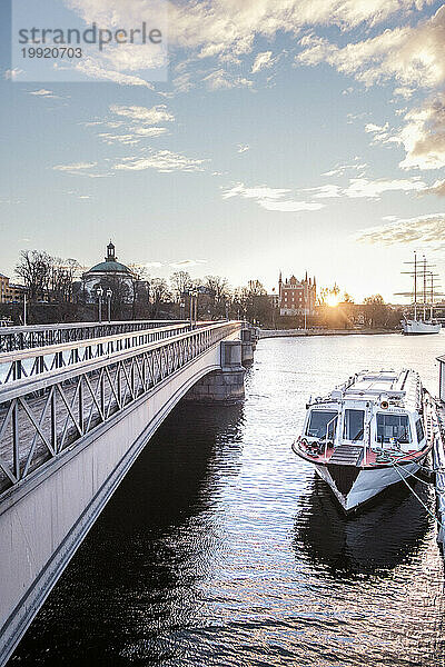 Brücke über den Fluss und Boot bei Sonnenuntergang  Stockholm  Schweden