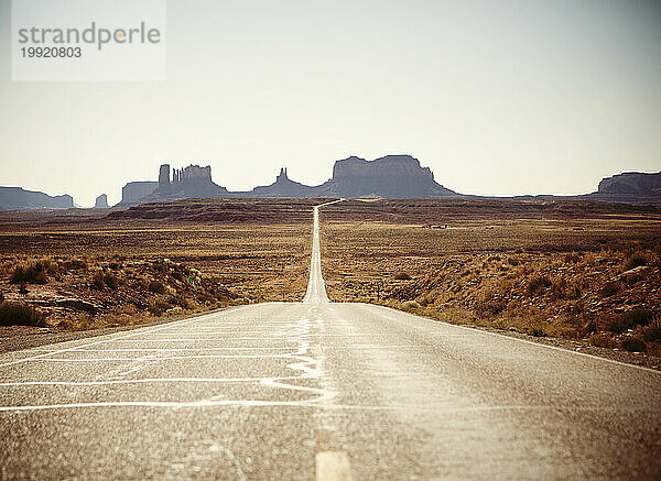 In diesem ikonischen Blick auf den amerikanischen Westen schlängelt sich eine einsame Straße durch das Monument Valley.