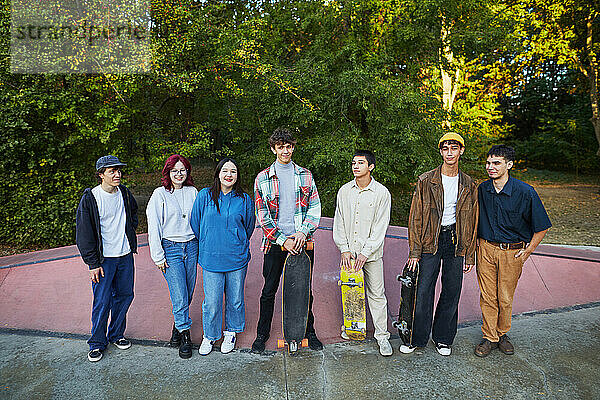 Eine Gruppe junger Leute mit Skateboards steht in einem Skatepark