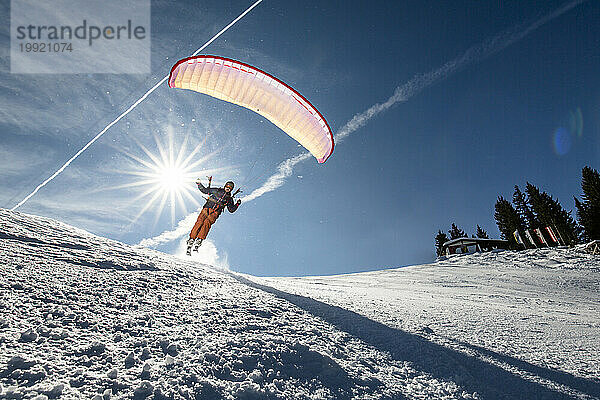 Mann fliegt im Winter in den österreichischen Alpen  Kitzbühel  Tirol  Österreich