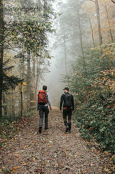 Zwei abenteuerlustige Männer wandern auf nebligen Bergpfaden