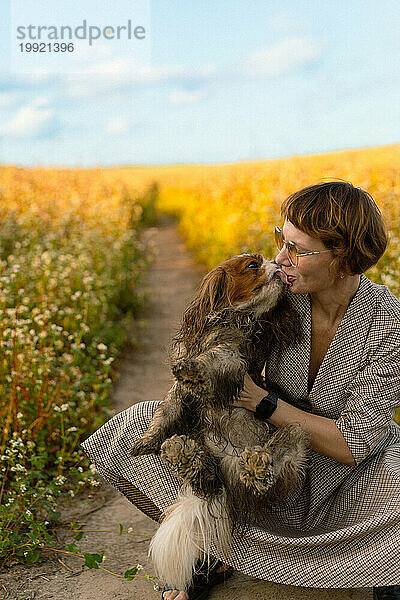 Eine Frau küsst ihren Hund. Freundschaft mit einem Haustier.