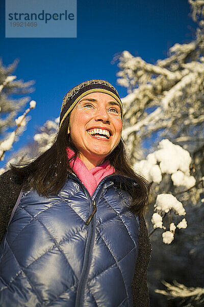 Eine erwachsene Frau genießt den Schnee und die Sonne in Homer  Alaska.