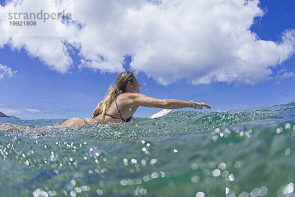 Mädchen paddelt Surfbrett