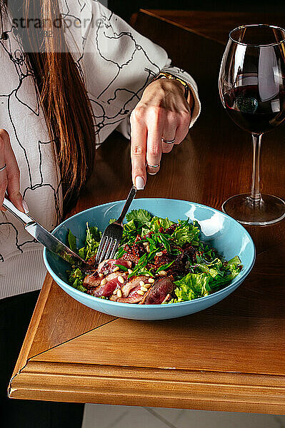 Das Mädchen hat einen Salat mit Ente