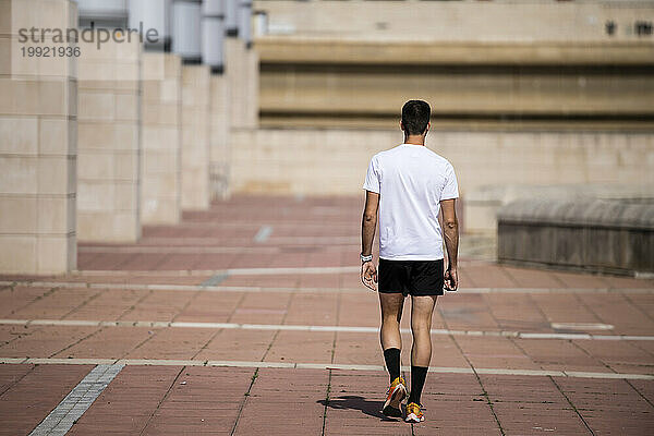 Rückansicht eines entspannten Läufers  der im Freien spaziert.