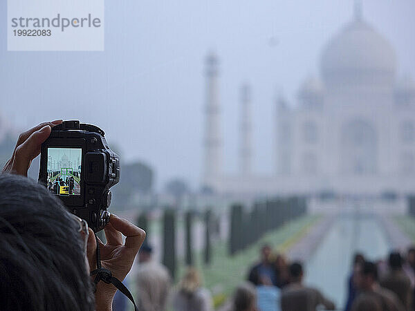 Person fotografiert Taj Mahal mit Kamera  Agra  Uttar Pradesh  Indien.