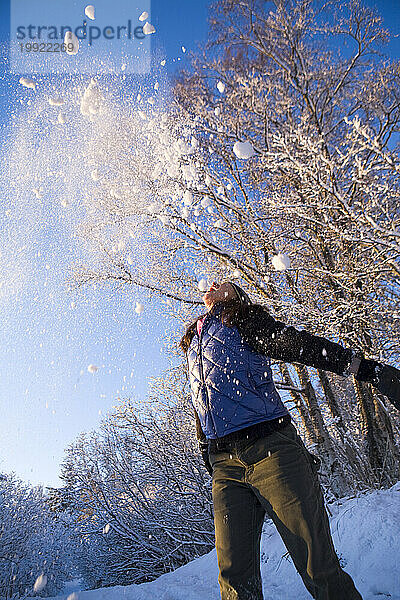 Eine erwachsene Frau spielt im Schnee in Homer  Alaska.