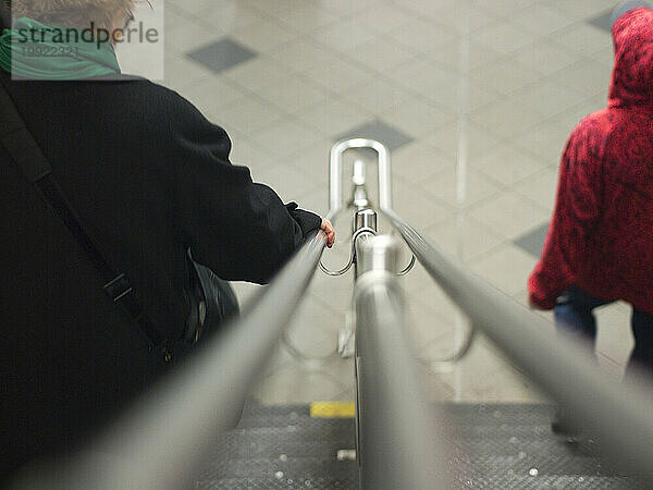 Eine Frau geht über das Geländer in der U-Bahn in New York  New York  USA  die Treppe hinunter.