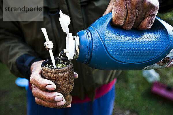 Mann gießt Wasser in seinen Partner in Patagonien  Argentinien