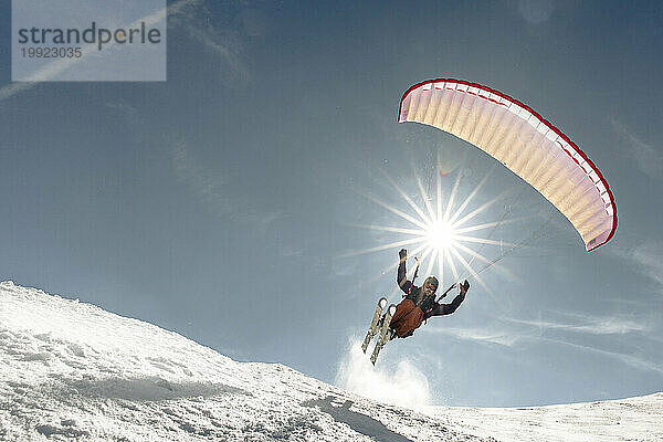 Mann fliegt im Winter in den österreichischen Alpen  Kitzbühel  Tirol  Österreich