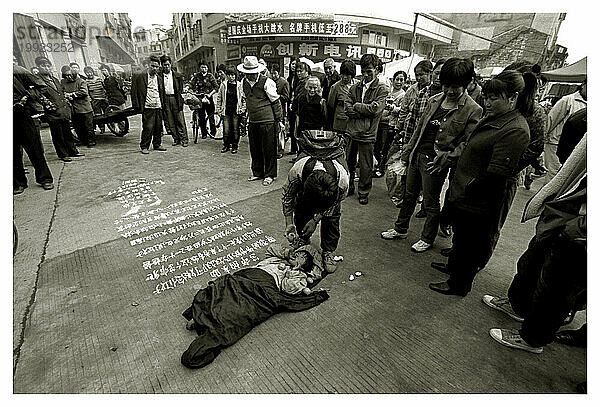 Ein Kind wird von seinem Bruder mitten auf die Straße gestellt  um um Essen und Geld zu betteln  Lianzhou  China.
