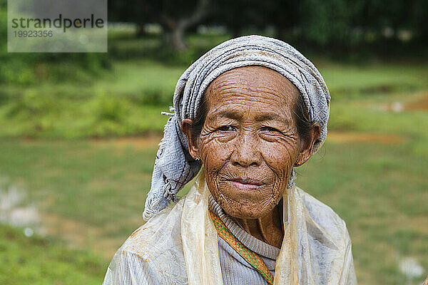 Porträt einer älteren Bäuerin  die draußen steht und in die Kamera blickt  Shan State  Myanmar